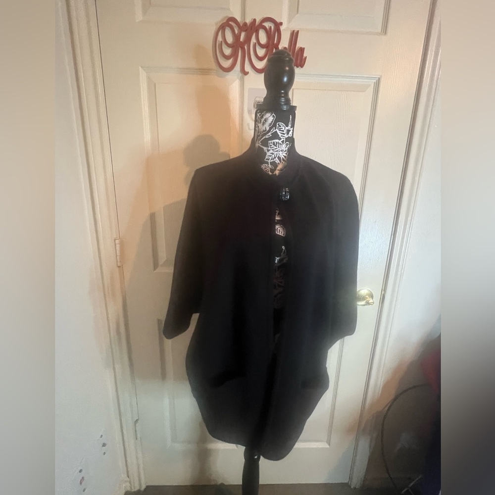 Well-loved Black cape with 2 front pockets that is a poncho style